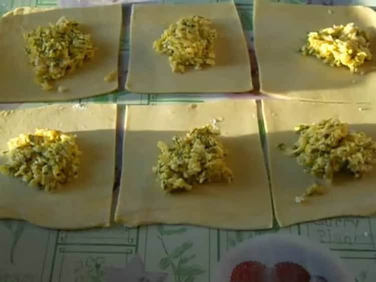 Um Khachapuri mit Blätterteigkäse zuzubereiten, geben Sie die Füllung auf den Teig