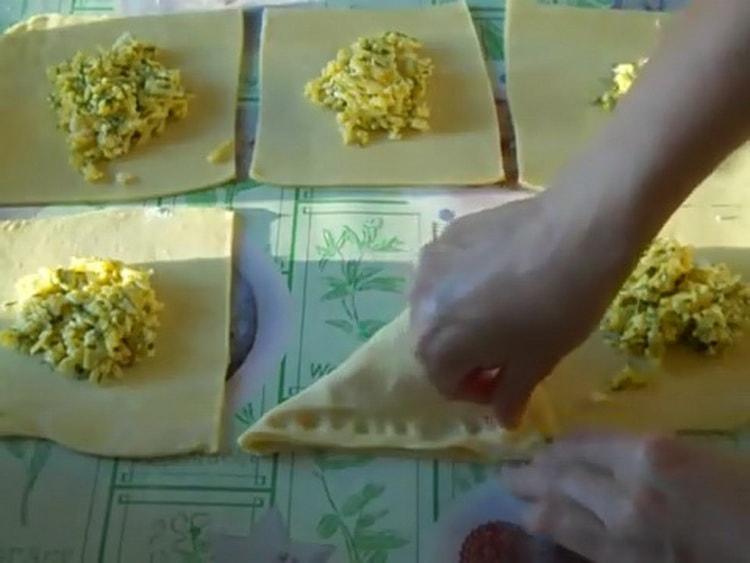 A khachapuri készítéséhez leveles tészta sajttal lezárja a tésztát