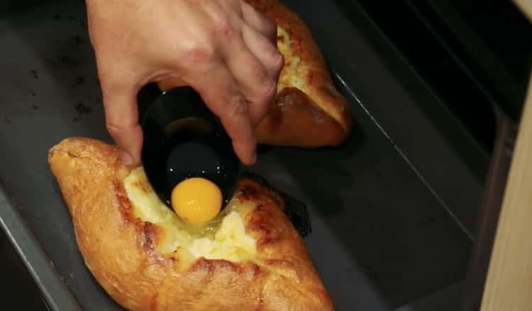 Fügen Sie Eigelb hinzu, um Khachapuri mit Ei und Käse zu machen