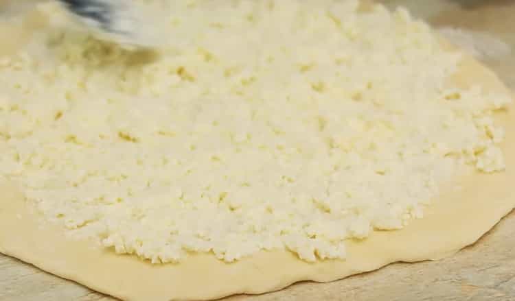 Um Khachapuri mit Ei und Käse zuzubereiten, geben Sie die Füllung auf den Teig
