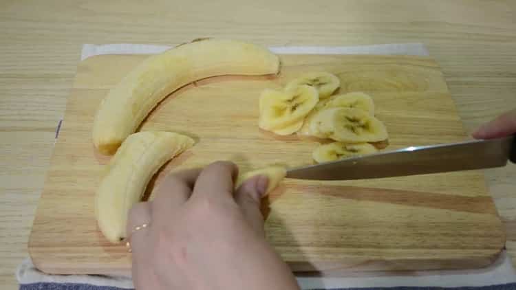 Schneiden Sie eine Banane, um ein Schokoladen-Bananen-Muffin zu machen
