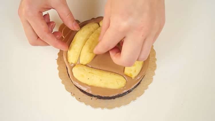 Um einen Schokoladen-Bananen-Kuchen zuzubereiten, legen Sie die Bananen auf den Kuchen