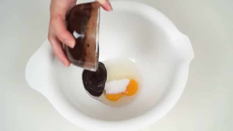 Sbattere le uova per fare una torta di banane al cioccolato.