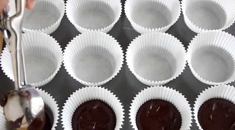 Per preparare cupcake al cioccolato, metti l'impasto negli stampi