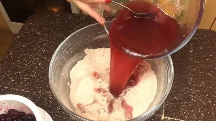 Mischen Sie flüssige und trockene Zutaten, um ein Schokoladenmuffin mit Kirsche zu machen