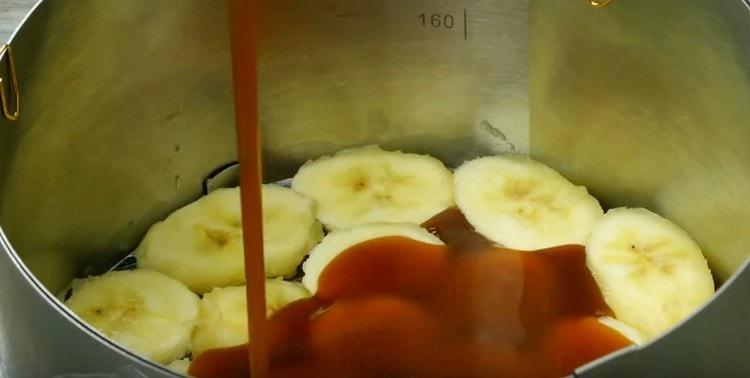Полученият карамел се изсипва върху слой банани.