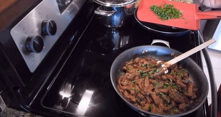 Έτοιμο Stroganoff από το βόειο κρέας με ξινή κρέμα μπορεί να ψεκαστεί με ψιλοκομμένα βότανα.