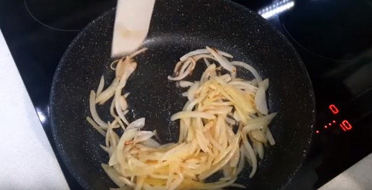 τηγανίζουμε το κρεμμύδι σε ένα τηγάνι μέχρι να ροδίσουν.