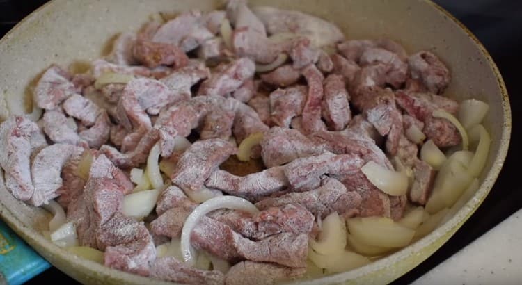 Διανέμουμε το βόειο κρέας σε αλεύρι σε μια κατσαρόλα στο κρεμμύδι και τηγανίζουμε μέχρι να ροδίσουν.