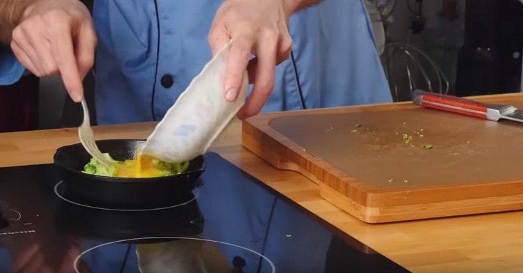 tedd a brokkoli darabokat egy serpenyőbe, töltsd meg tojással és főzzük a fedél alatt.