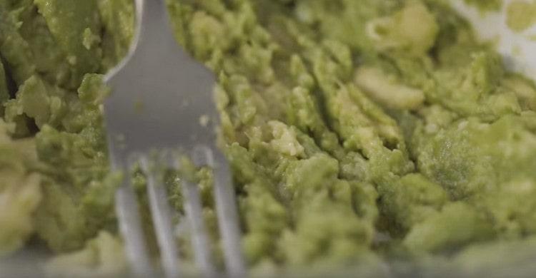 Impastare la polpa di avocado schiacciato con una forchetta.