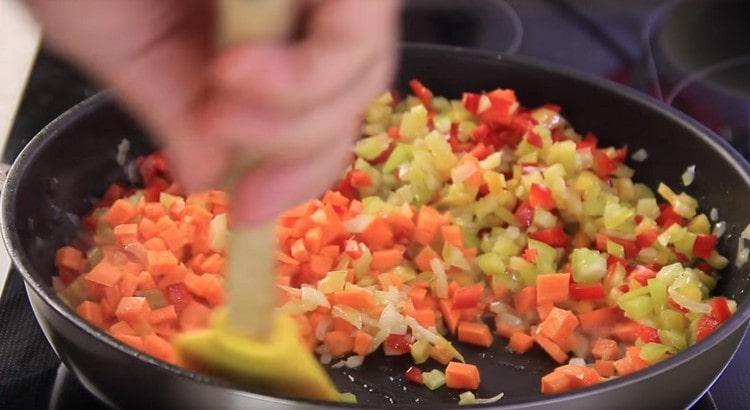 Fügen Sie Karotten und Pfeffer der Zwiebel hinzu.