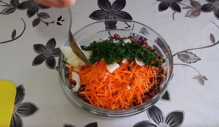 Do salátu přidejte cibuli s bylinkami, nasolte jídlo.
