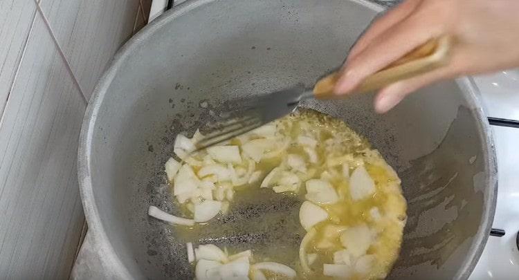 Σε λάδι, τηγανίζουμε το κρεμμύδι κομμένο σε μισά δαχτυλίδια.
