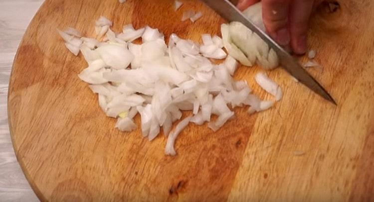Για να προετοιμάσετε τη σάλτσα, ψιλοκόψτε το κρεμμύδι.