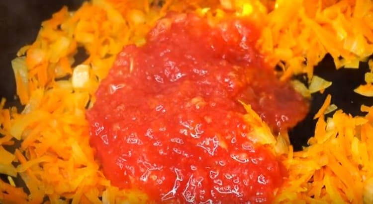 Fügen Sie Karotten der Zwiebel in der Pfanne hinzu, und nach ein paar Minuten gehackte Tomaten.