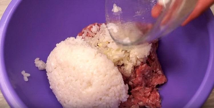 V misce kombinujeme mleté ​​maso, cibuli s česnekem a rýží.