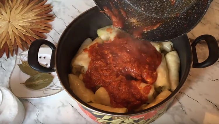Įdarytus kopūstus į lėkštę užpilkite pomidorų padažu.