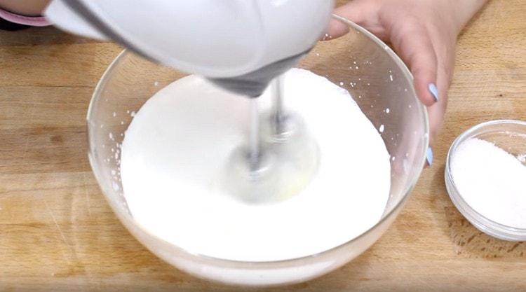 Για να προετοιμάσετε το γέμισμα, μαντίστε την κρέμα με ζάχαρη.