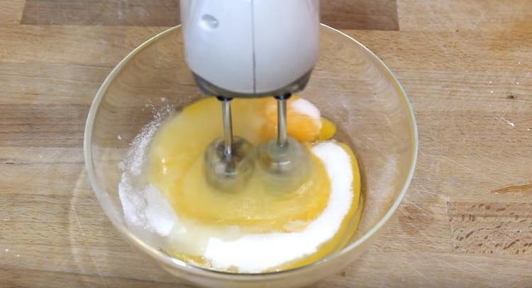 Χτυπάμε ξεχωριστά τα αυγά με ζάχαρη.