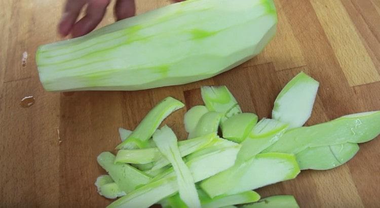 Sbucciare la buccia dalle zucchine.
