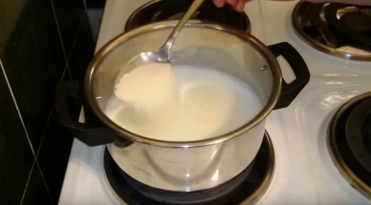 Gießen Sie 3 Esslöffel Grieß in kochende Milch.
