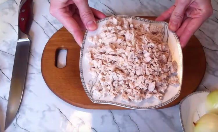 Нарежете свареното пилешко филе на парчета.