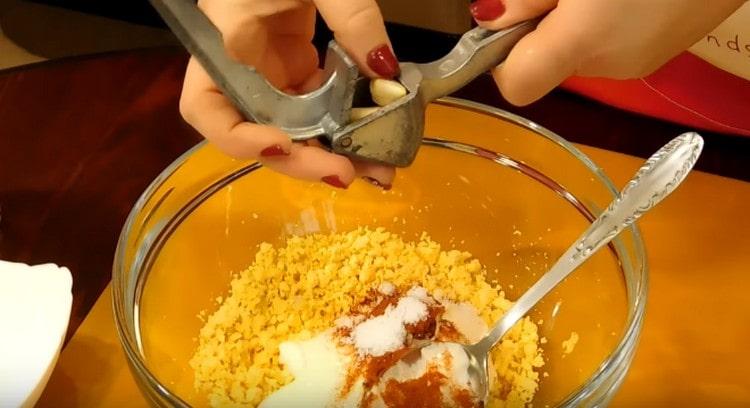 Con una pressa spremi l'aglio nella massa del tuorlo.