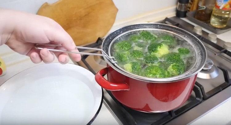 Wir verteilen Brokkoli in gekochtem Salzwasser.