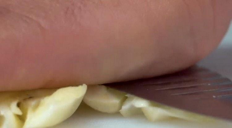 L'aglio schiaccia semplicemente il lato piatto del coltello.