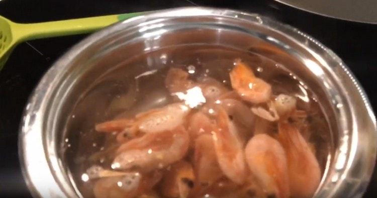 Wir legen gefrorene Garnelen in kochendes Wasser.