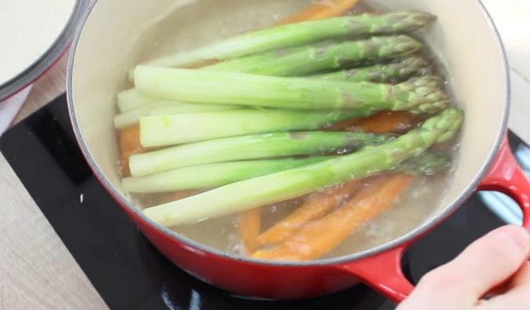 Idagdag ang asparagus sa kawali sa mga karot.