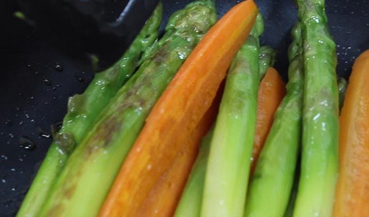 Прехвърляме сварените зеленчуци в тигана и леко запържваме.