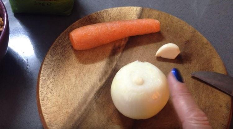 Karotten und Zwiebeln waschen und hacken.