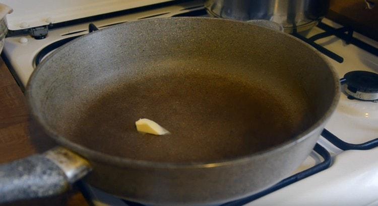 ζεσταίνετε το τηγάνι, απλώστε ένα κομμάτι βούτυρο.