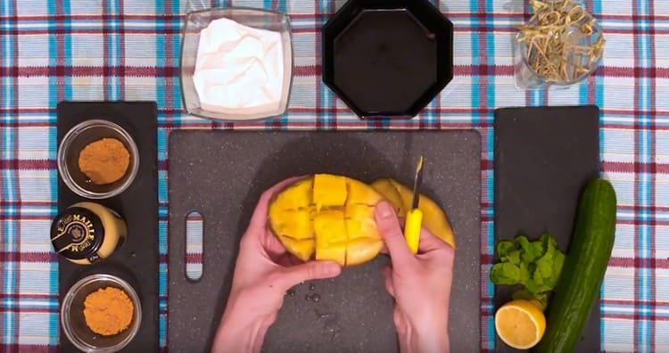 Sbucciare e tagliare a pezzi il mango.