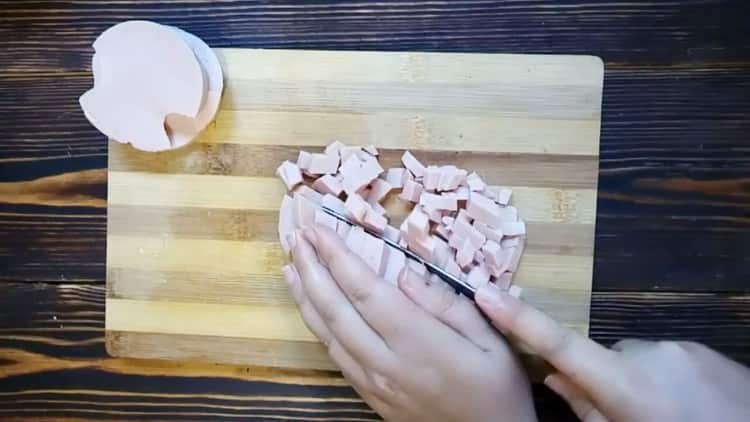Per cucinare okroshka, tagliare la salsiccia