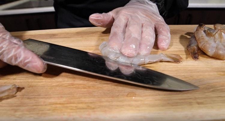 Iškirpkite krevetes išilgai nugaros ir pašalinkite stemplę.