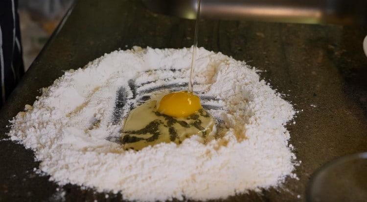 Разбиваме яйцето в брашното.