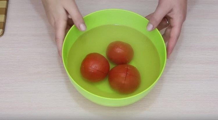 Versa dell'acqua bollente sui pomodori.