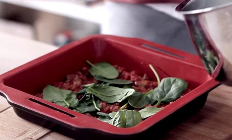 Distribuire le foglie di basilico sopra la salsa.