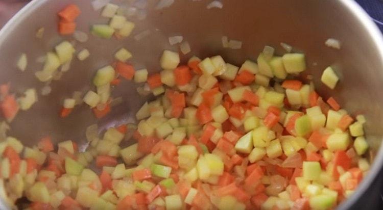Добавете моркови, тиквички и оставете да къкри зеленчуците заедно.