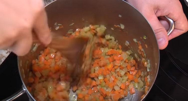 Fügen Sie Karotten und Sellerie der Zwiebel hinzu.
