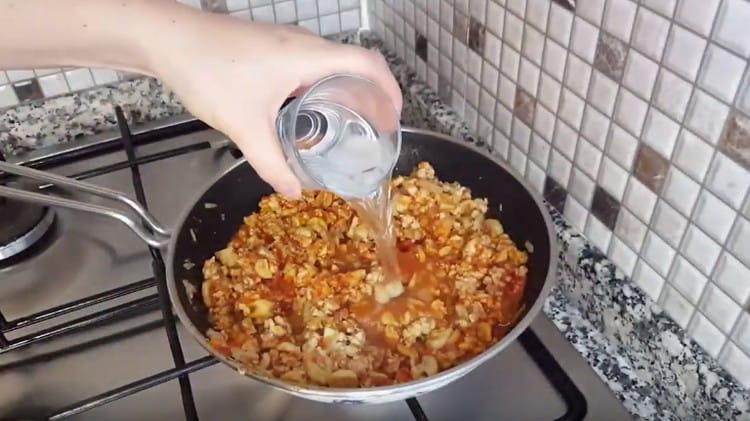 Сега добавете доматеното пюре, доматеното пюре и водата.