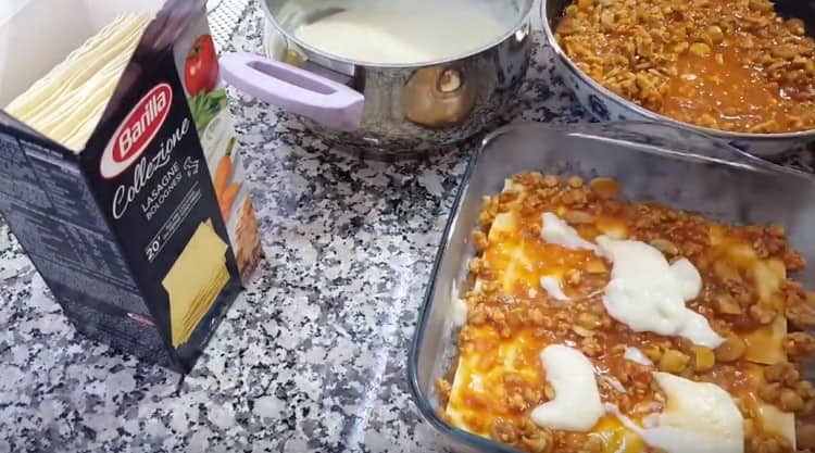 Als nächstes legen Sie die Blätter der Lasagne aus und decken Sie wieder mit Saucen.