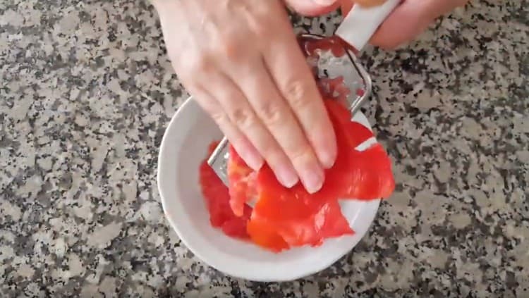 Reiben Sie die Tomate auf einer Reibe.