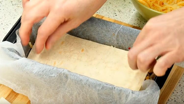 Καλύψτε το στρώμα τυριού με ψωμί πίτας και επαναλάβετε τα στρώματα.