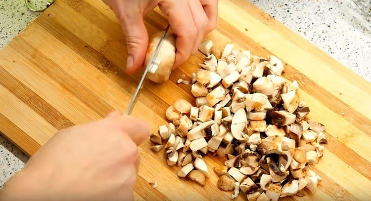 Pilze in kleine Würfel schneiden.