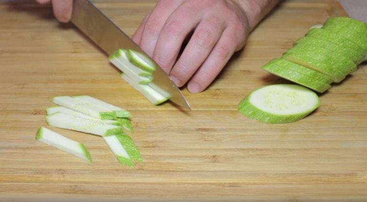 Zucchini in dünne Stäbchen schneiden.