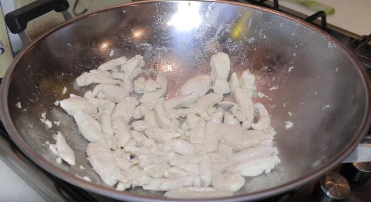 Friggere la carne in una padella per wok.